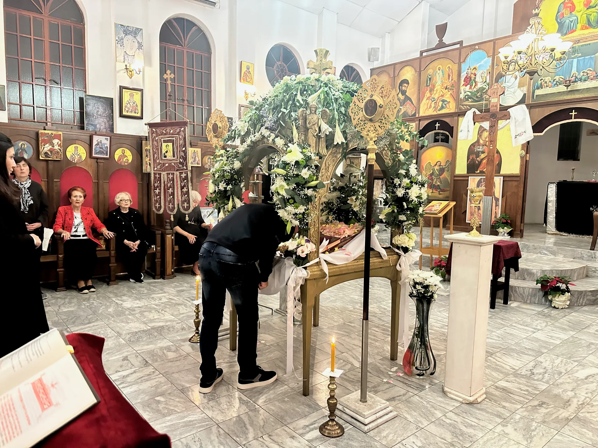 The Plashtanica (Epitaphios) adorned with flowers during Holy Friday services for Pascha.