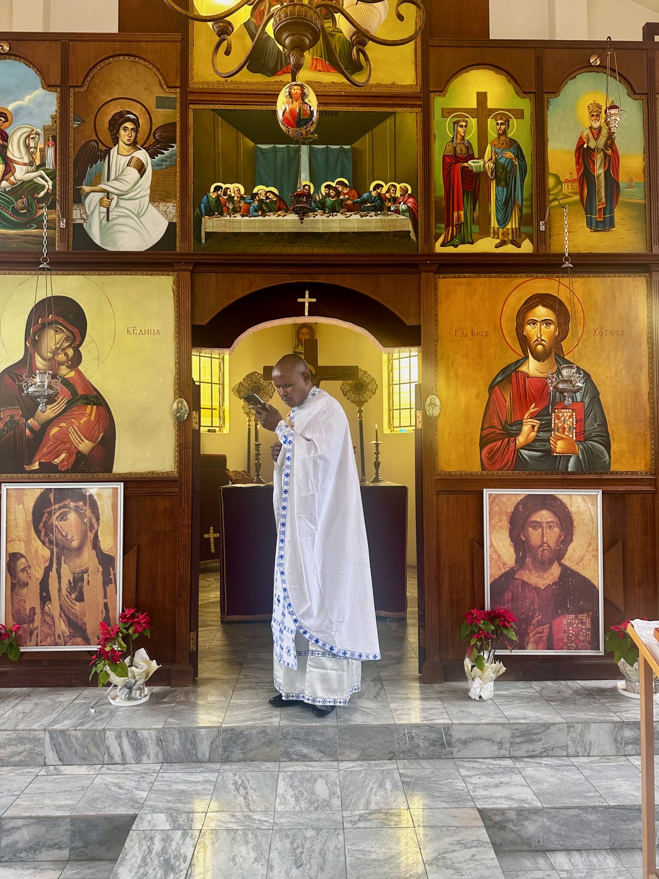 Father Markos standing in front of the iconostasis before a service