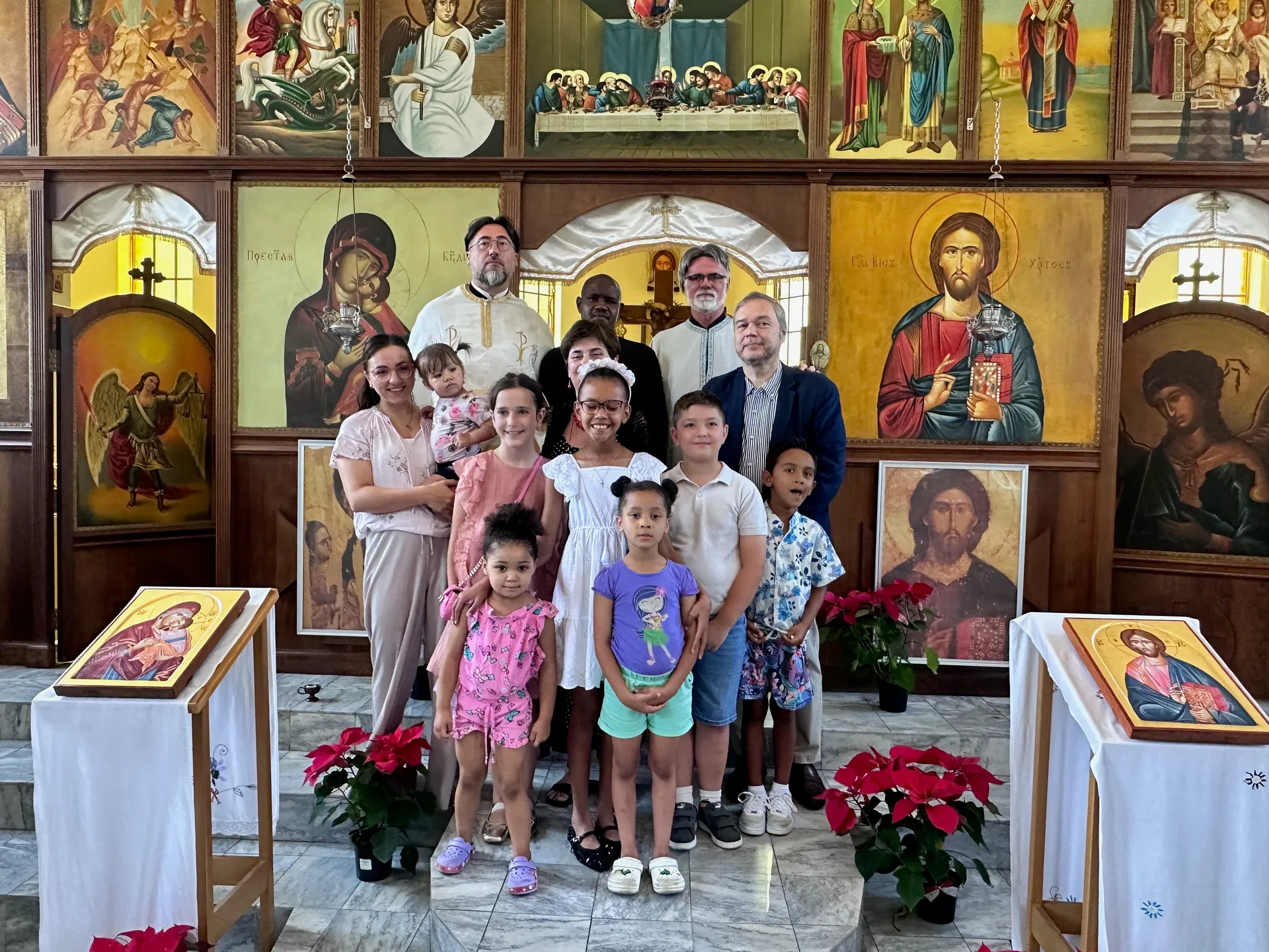 A bishop, the Serbian ambassador, Father Markos, Father Isajlo, and Sunday School children gathered before the iconostasis
