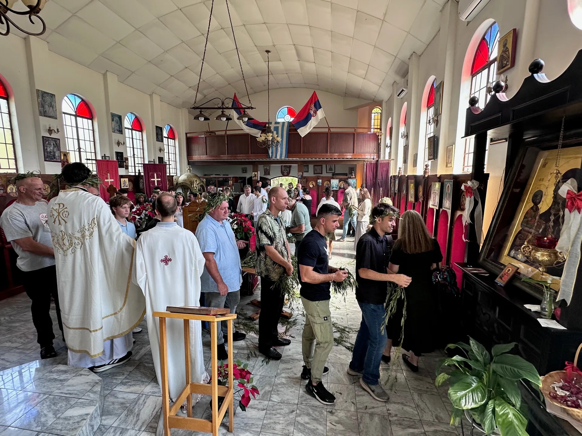 Clergy blessing the faithful as parishioners hold palms during Palm Sunday
