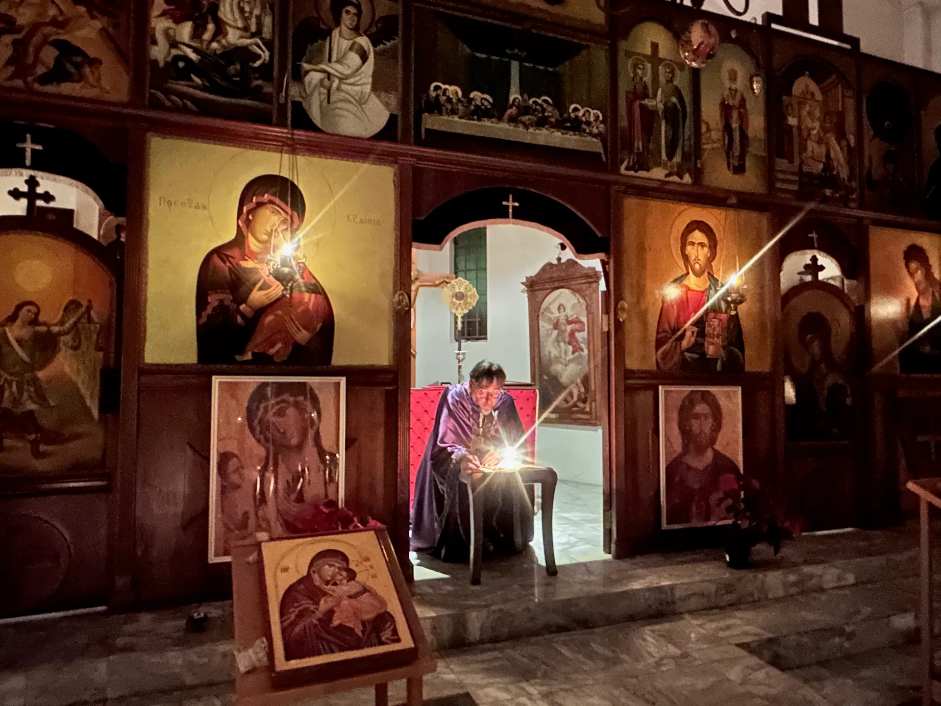 Candles glowing before the iconostasis during the Service of the Twelve Passion Gospels on Great and Holy Thursday